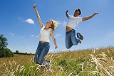 Couple jumping in a field